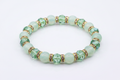 Bracelet opaline cristaux verts rondelles dorées sur fond blanc