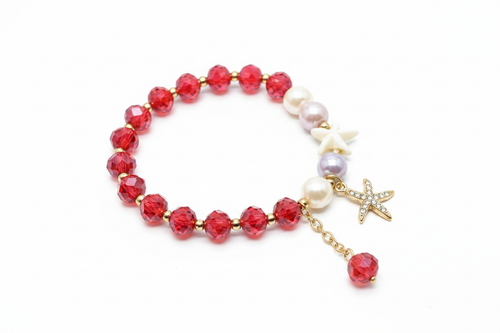 Bracelet cristaux rouges étoile de mer dorée sur fond blanc